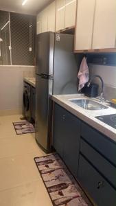 a kitchen with a stainless steel refrigerator and a sink at Apartamento ao lado do Mercado Central Edifício Fidelis in Goiânia