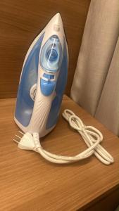a blue and white iron with a cord on a table at Apartamento ao lado do Mercado Central Edifício Fidelis in Goiânia