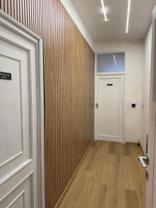 a hallway with a white door and a wooden wall at Civico 8 Apartment in Sassari