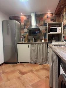 a kitchen with a refrigerator and a microwave at Casa Carmen I in Montoro