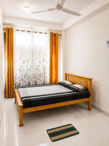 a bedroom with a wooden bed in front of a window at Papa's Resort Dunhinda in Hinnarangahakumbura