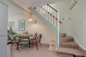 a dining room with a table and chairs and a staircase at Three Peaks Central Cottage, Settle, 3Bed 2Bath in Settle