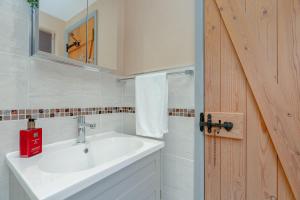 a bathroom with a white sink and a mirror at Three Peaks Central Cottage, Settle, 3Bed 2Bath in Settle