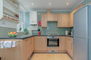 a kitchen with wooden cabinets and a refrigerator at Three Peaks Central Cottage, Settle, 3Bed 2Bath in Settle +26 photos
