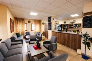 a waiting room with chairs and a bar at Hotel Jantar Dudince in Dudince