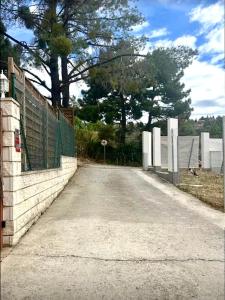 an empty road with a fence and trees in the background at El Rinconcito de La Suiza in Robledo de Chavela