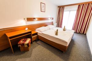 a hotel room with a bed and a desk at Hotel Jantar Dudince in Dudince +13 photos