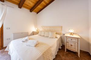 a bedroom with a bed and a table with a night stand at Agriturismo Cirra in Tertenìa