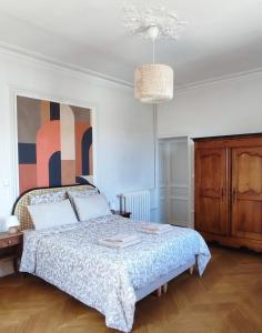 a bedroom with a bed and a painting on the wall at Particulier & Pro - 4 chambres - 8 pers - Jaude avec parking privée in Clermont-Ferrand