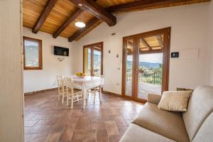 a living room with a table and chairs and a couch at Agriturismo Cirra in Tertenìa