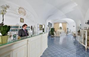 a woman standing in front of a counter in a restaurant at Hotel San Felice in Capri