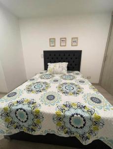 a bedroom with a bed with a floral bedspread at Imperial house in Envigado