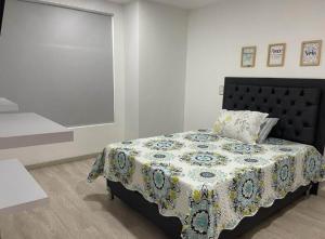 a bedroom with a bed with a quilt on it at Imperial house in Envigado +2 photos