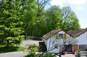 a house in the middle of a yard with trees at Gîte La Maison Du Parc in Argilly