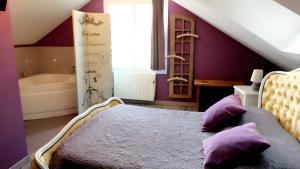 a bedroom with purple walls and a bed with purple pillows at Gîte La Maison Du Parc in Argilly