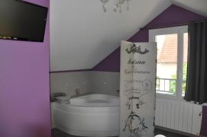 a bath tub in a bathroom with a purple ceiling at Gîte La Maison Du Parc in Argilly +13 photos
