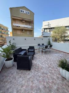 a patio with couches and tables and chairs on a building at Civico 8 Apartment in Sassari