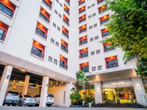a large white building with cars parked in it at Atrium Boutique Hotel in Bangkok