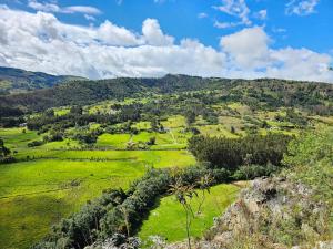 a view of a green field with mountains in the background at Casa del Oro in Suesca