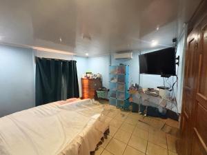 a room with a bed and a flat screen tv at Elsie Place in San Mateo