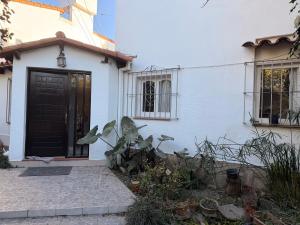 a white house with a black door and some plants at Marea in San Lorenzo
