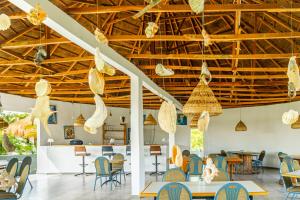 a room with chairs and tables and wooden ceilings at Tanema Creek in Brufut