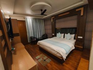 a bedroom with a large bed and a television at Summer Hill Resort in Chail