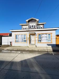 a large white house on the side of a street at Hostel 53 Sur in Puerto Natales