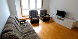 a living room with a couch and two chairs and a television at EnSAN CIPRIAN Playas y Relax in San Ciprián