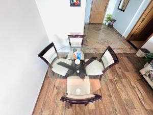 a glass table with four chairs around it at Penta Prestige Hotel Apartments DHA Lahore - LMY Hospitality in Lahore