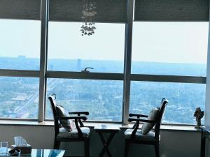 a room with two chairs and a table in front of a window at Penta Prestige Hotel Apartments DHA Lahore - LMY Hospitality in Lahore
