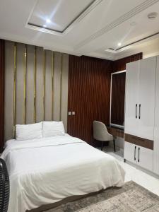 a bedroom with a white bed and a desk at Verse Living in Abuja
