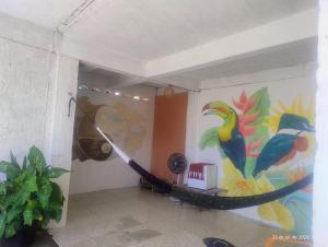a room with a hammock and a painting on the wall at hostel xamã in Flecheiras +34 photos