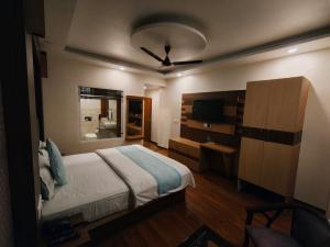 a bedroom with a bed and a television in it at Summer Hill Resort in Chail