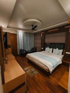 a bedroom with a large bed and a television at Summer Hill Resort in Chail