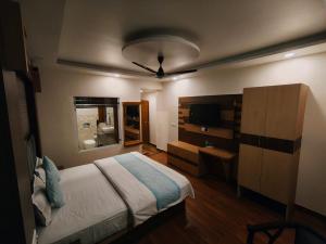 a bedroom with a bed and a dresser and a television at Summer Hill Resort in Chail