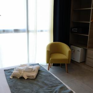 a bedroom with a bed and a yellow chair at EVASION by LIBERTE in Oran +49 photos