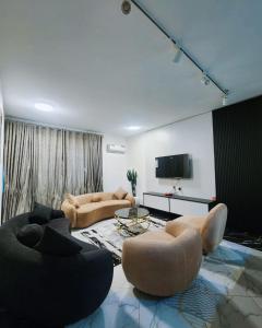 a living room with two couches and a tv at Verse Living in Abuja