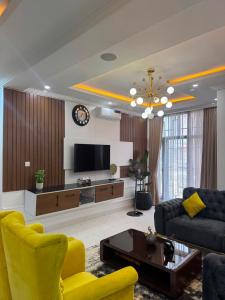 a living room with a couch and a tv at Verse Living in Abuja