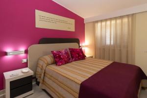 a bedroom with a bed with a purple wall at Resid Enza Palazzo Sciacca in Patti