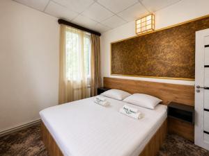 a bedroom with a bed with two towels on it at Sochi Resort-Pine Garden Boutique Hotel and Pool Stepanavan in Stepʼanavan