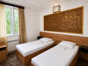 a hotel room with two beds and a painting on the wall at Sochi Resort-Pine Garden Boutique Hotel and Pool Stepanavan in Stepʼanavan