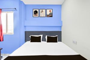 a blue bedroom with a large bed with two pillows at Hotel O HOLIDAY STAR IN in Hyderabad