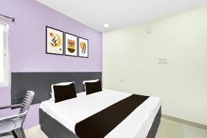 a bedroom with a large bed and a purple wall at Hotel O HOLIDAY STAR IN in Hyderabad
