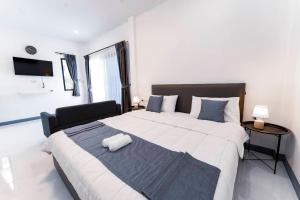 a bedroom with a large bed with a black and white blanket at NS Khaolak Resort in Khao Lak
