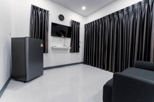 a living room with black curtains and a tv at NS Khaolak Resort in Khao Lak