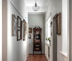 a hallway with white walls and a hallway with paintings at Raphael Rooms in Peterborough