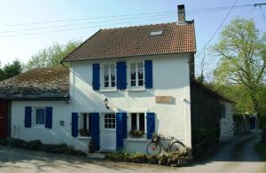 a white house with blue shutters and a bicycle at Villa Felinas in Ahun