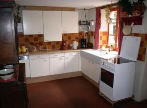 a kitchen with white cabinets and a white stove top oven at Villa Felinas in Ahun +11 photos