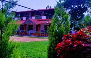 a house with a red roof and a green yard at Estateview Villa Homestay in Sakleshpur